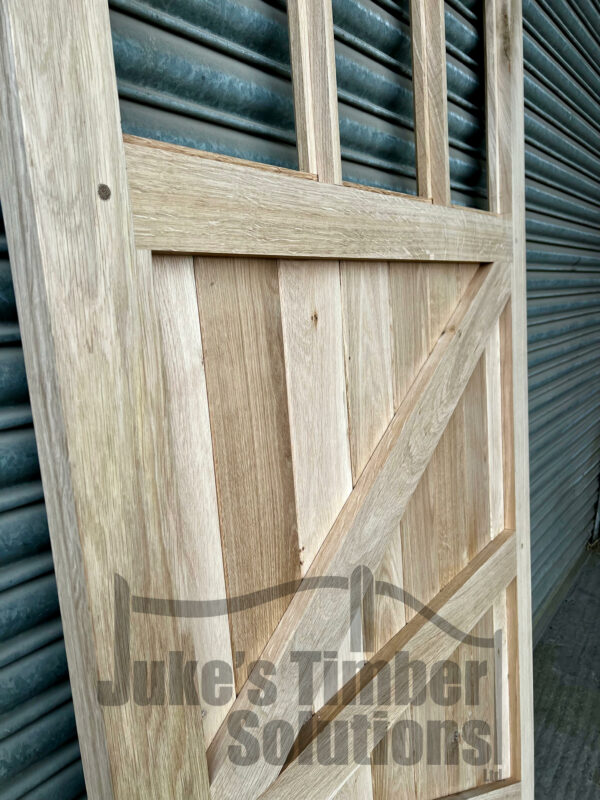 Close up of an oak 3 pane garage side door, showing the detailing of framing, ledging and bracing