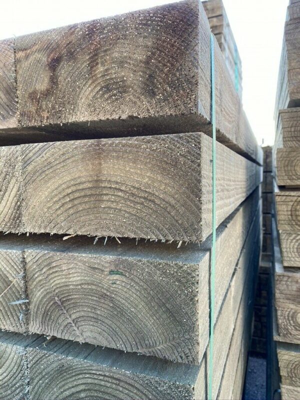 Stacked bundles of green treated timber railway sleepers