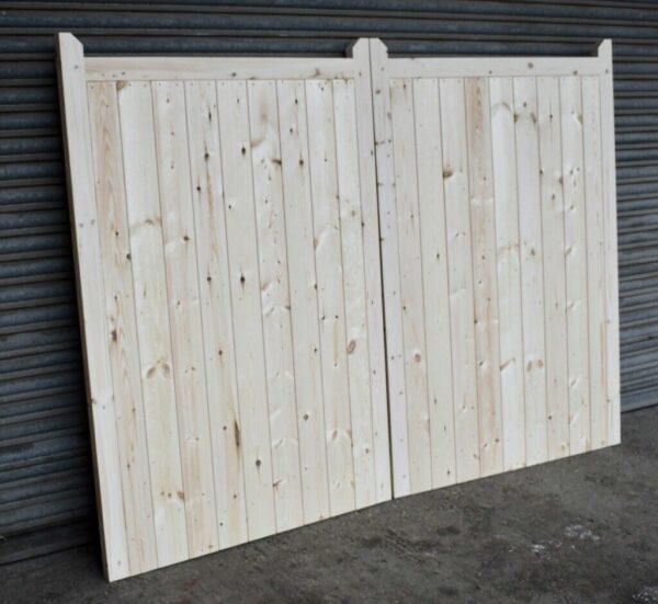 Wooden driveway gates leaning against metal shutters
