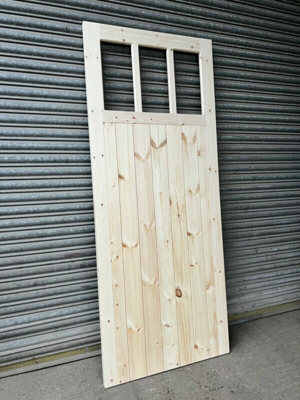 3 pane wooden side garage door leaning against metal shutters