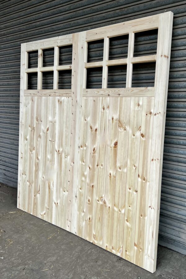 Side on view of wooden 12 pane garage doors against metal shutters