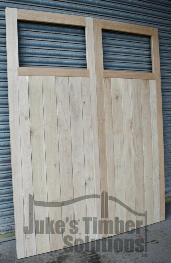 Oak single pane framed, ledged and braced garage doors leaning against metal shutter