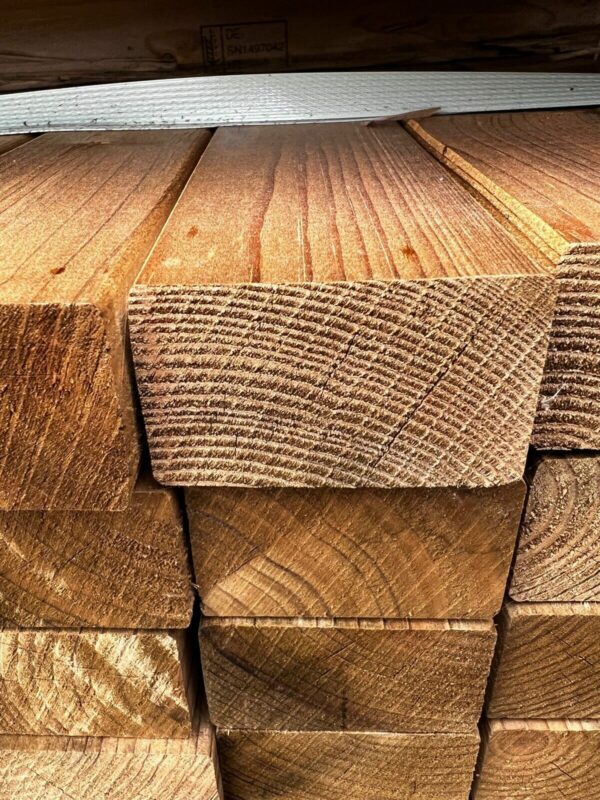 Close up of tanalised CLS timber lengths, stacked in packs.