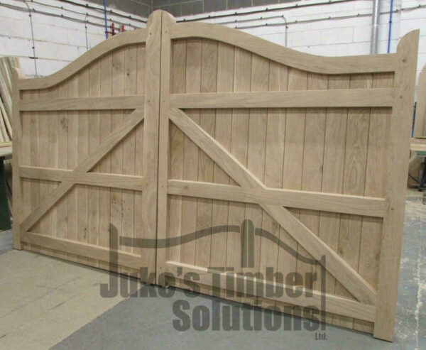 Wooden oak swan neck driveway gate in workshop, showing the detailing of ledging and bracing.