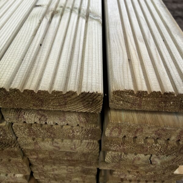Stacked planks of treated wooden timber decking