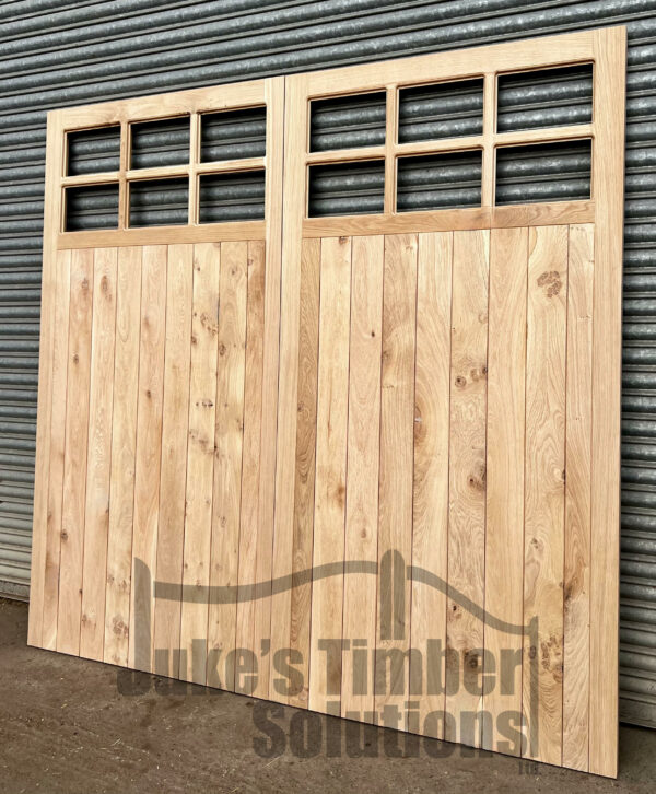 Overview of 12 pane wooden oak garage doors, leaning against metal shutters