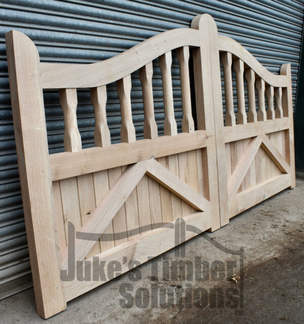 Overview of a oak swan neck spindle gate in front of metal shutters