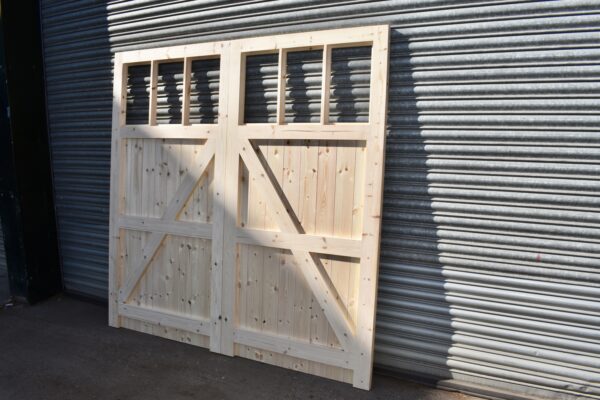 Rear detailing of wooden garage doors, leaning against metal shutters, showing framed, ledged and braced detailing.