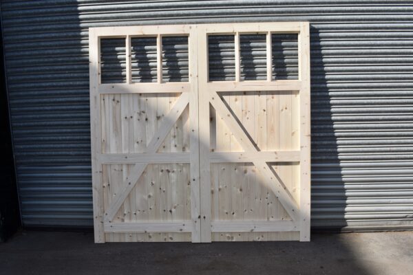 Overview image of a heavy duty wooden garage door with 6 panes. Pictured in front of metal shutters.