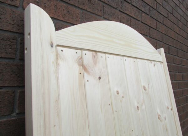 Close up on the detailing and craftsmanship at the top of a garden curved top side gate