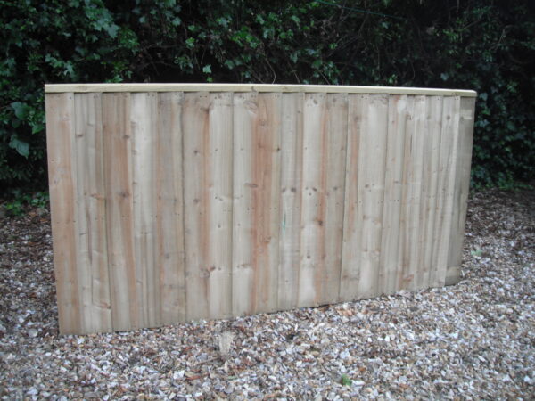 A length of heavy duty wooden fence panels, pictured in a garden.