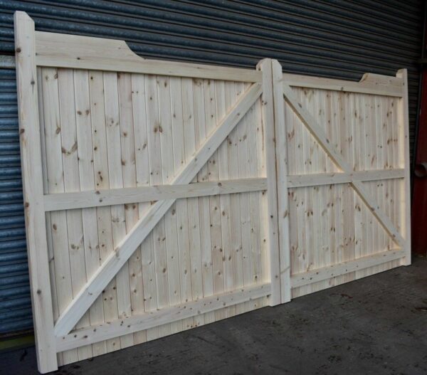 Softwood gunstock driveway gates leaning against metal shutters