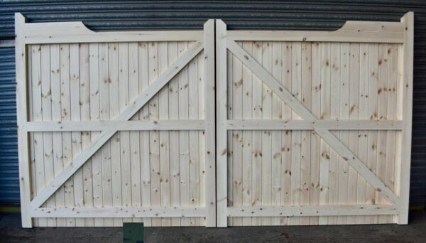 Rear of softwood gunstock driveway gates, leaning against metal shutters