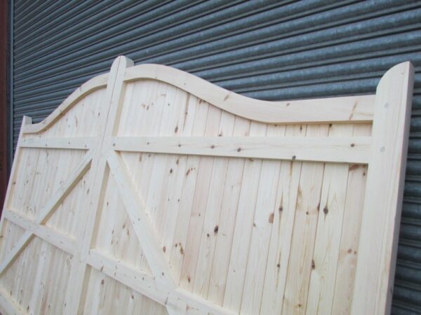 Close up of the top of softwood swan neck driveway gates