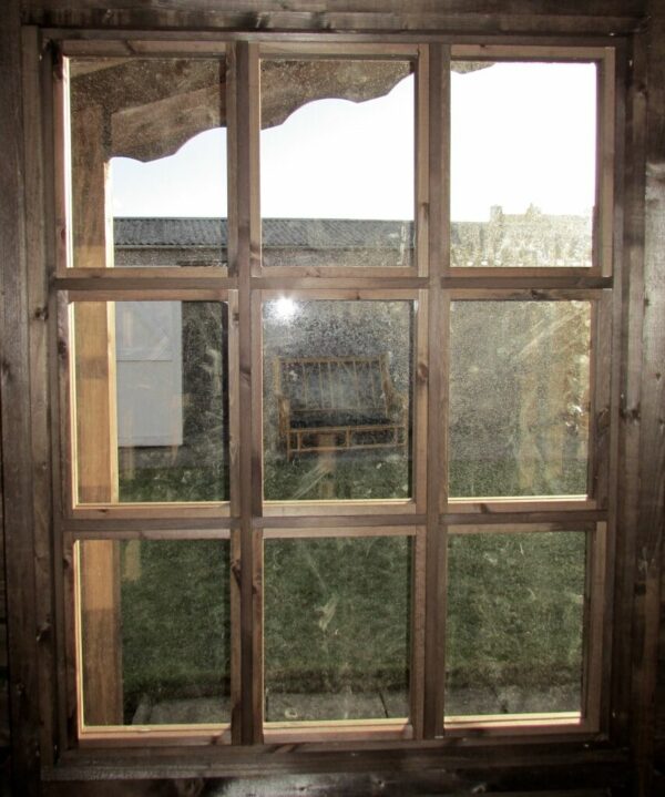Close up of the window of a summer house log cabin, with 9 panes