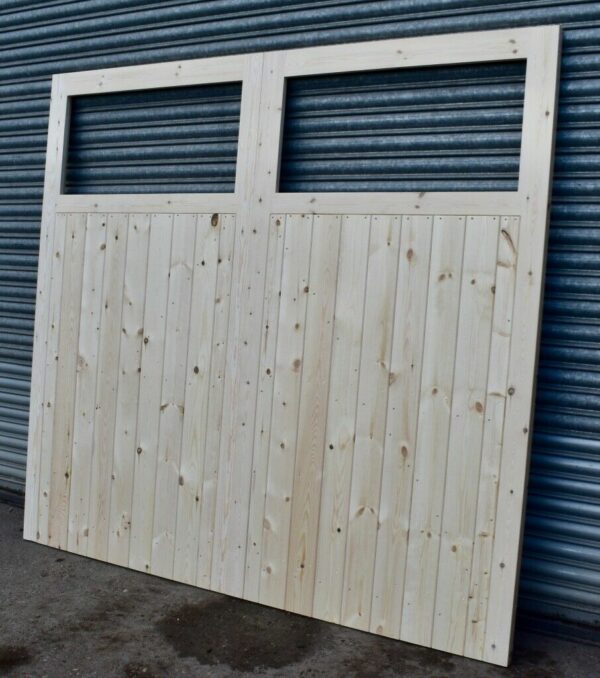 Single pane wooden garage doors leaning against metal shutters