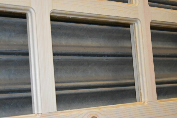 Close up of craftsmanship of panes on 6 pane garage door. Showing metal shutters through the pane.