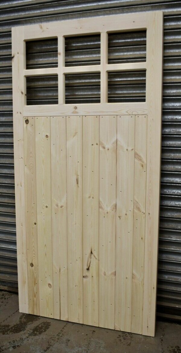 Wooden side garage door leaning against metal shutter