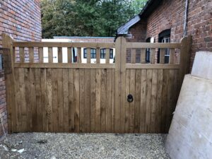 Oak 1/3 2/3 split palisade driveway gate fitted onto gravel driveway